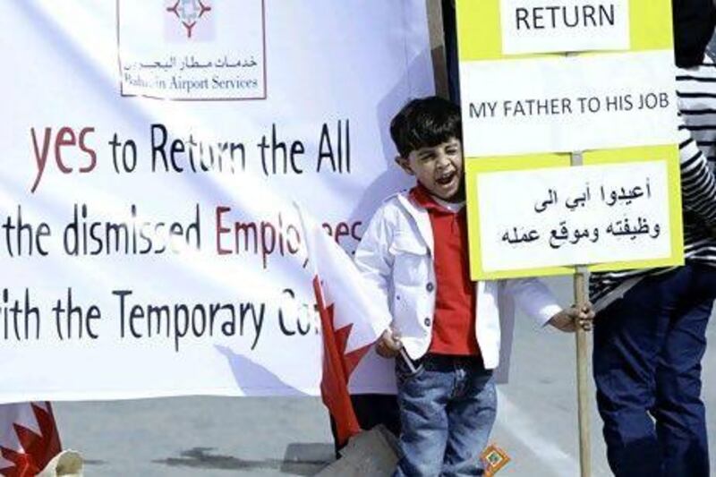 A Bahraini boy seems less than enthusiastic at a protest outside the ministry of labour in Isa Town.Hasan Jamali / AP Photo