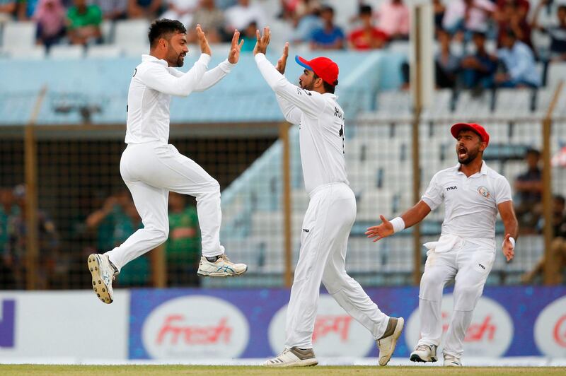 Afghanistan cricketer Rashid Khan (L) celebrates with his teammates after the dismissal of Bangladesh cricketer Musfiqur Rahim during the fourth day of the one-off cricket Test match between Bangladesh and Afghanistan at the Zohur Ahmed Chowdhury Stadium in Chittagong on September 8, 2019. / AFP / STR
