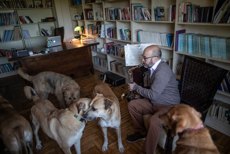 Mr Akkok entertains his canine friends by playing the saxophone. EPA 