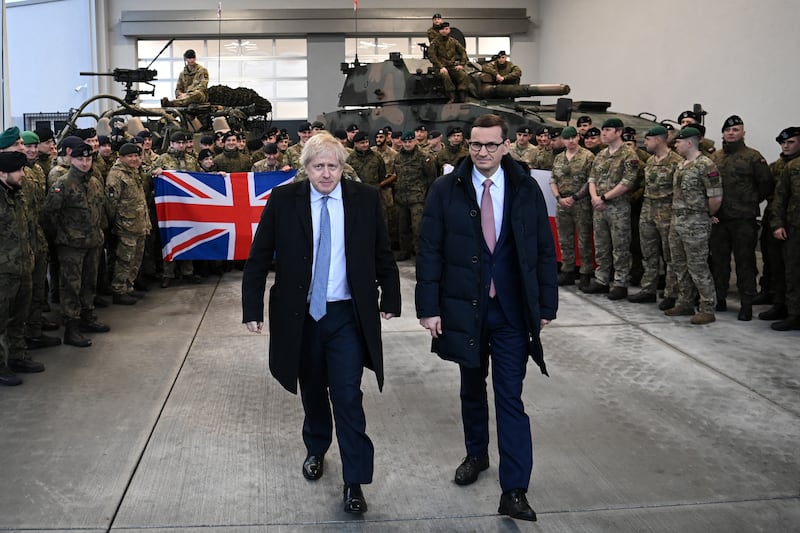 Boris Johnson and Mateusz Morawiecki pose for a photograph with British and Polish troops at Warszawska Brygada Pancerna military base. Getty Images