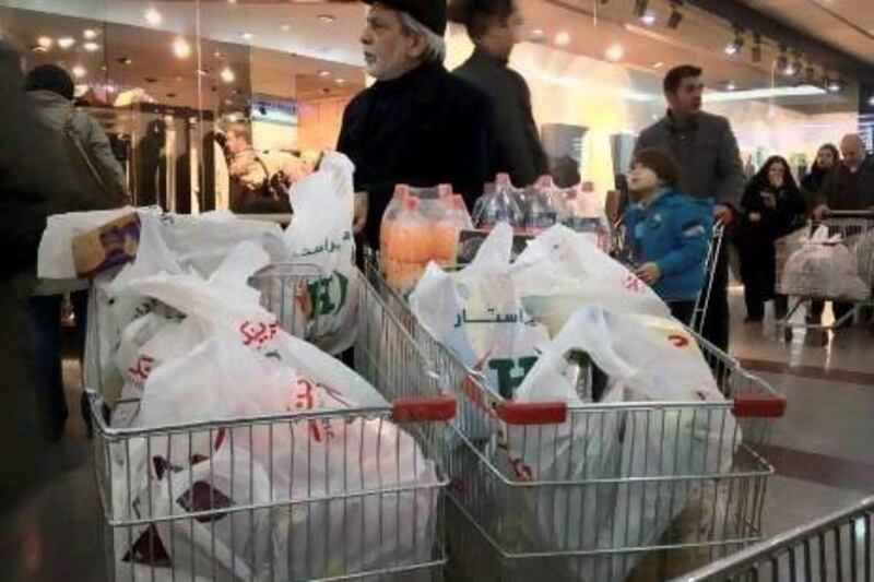 An Iranian shopper stands beside his trolleys in a Tehran supermarket. Sanctions have caused disruption to imports, with the price of rice doubling to US$5 a kilo, and meat $30 a kilo.
