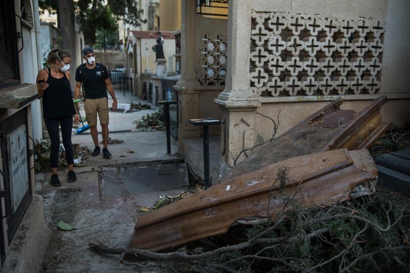 People observe two coffins, damaged by Tuesday's massive explosion that rocked the city, in Beirut, Lebanon. Getty Images