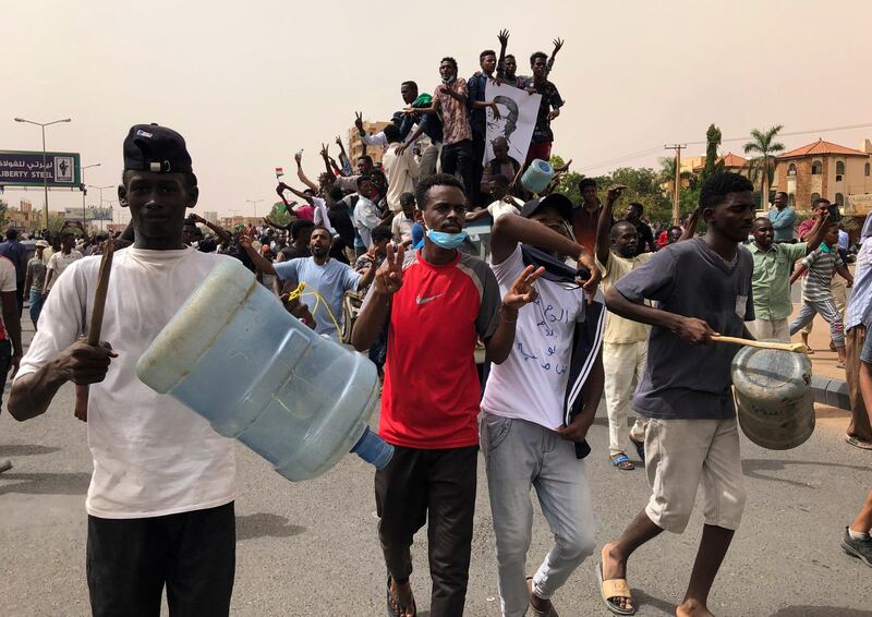Sudanese protesters beat water containers during a demonstration against the military council, in Khartoum, Sudan, on Sunday, June 30, 2019. AP Photo