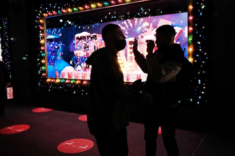 People look at the newly revealed Macy's Herald Square holiday windows in New York City. This year's windows look to give thanks to the city and those who worked on the frontlines of the Coronavirus pandemic. AFP