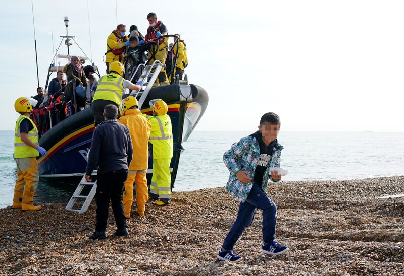 A group of people are brought ashore in Dungeness, Kent, after being rescued in the Channel in September 2022. PA