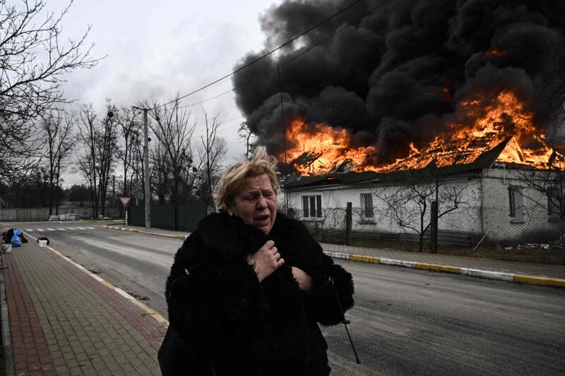 A house burning after being shelled in the city of Irpin, outside Kyiv. The conflict could reduce global GDP by 1% by 2023. AFP