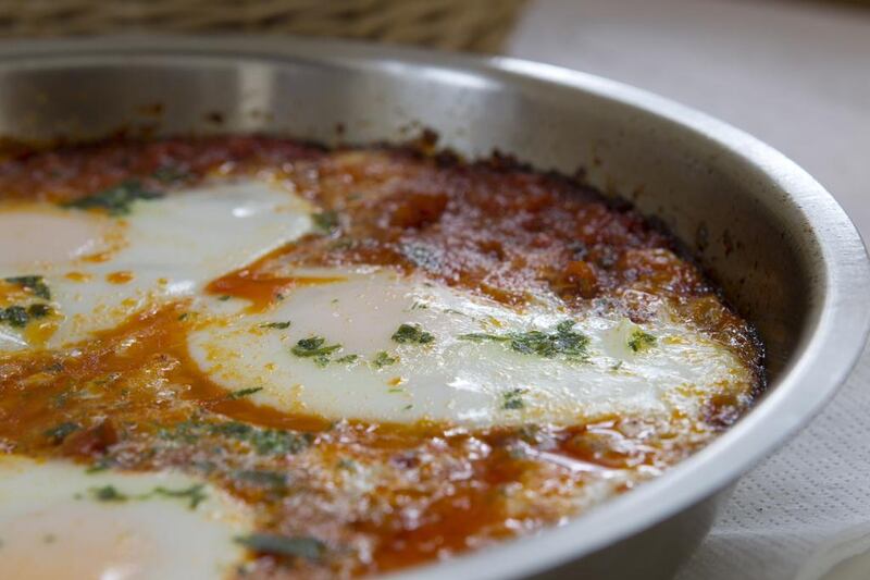 Shakshouka is pictured at Baker & Spice cafe in the Dubai Marina. The dish contains four eggs poached in tomato, roasted red peppers and red chilli sauce and is extremely popular both on weekdays and weekends. It is often accompanied by french farmhouse bread. Razan Alzayani / The National