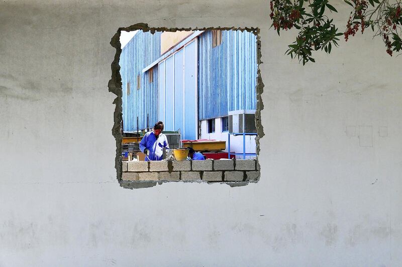 Workers constructing a wall at the Gulf Craft in Umm Al Quwain on April 28,2021. Pawan Singh / The National