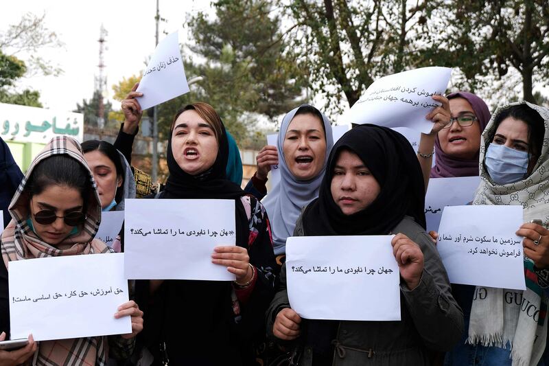 Women hold placards at a protest in Kabul calling for the international community to speak out in support of Afghans living under Taliban rule. AFP