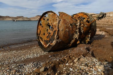 A rusted metal barrel, near the location of where a different barrel was found containing  a human body, sits exposed on shore during low water levels due to the western drought at the Lake Mead Marina on the Colorado River in Boulder City, Nevada on May 5, 2022.  - A worsening drought has revealed a four-decade-old body dumped in Lake Mead, police said May 2, 2022, warning that falling water levels would lead to the uncovering of more corpses.  Boaters on Lake Mead near Las Vegas discovered a corroded barrel with its sinister contents during a weekend pleasure trip.  (Photo by Patrick T.  FALLON  /  AFP)