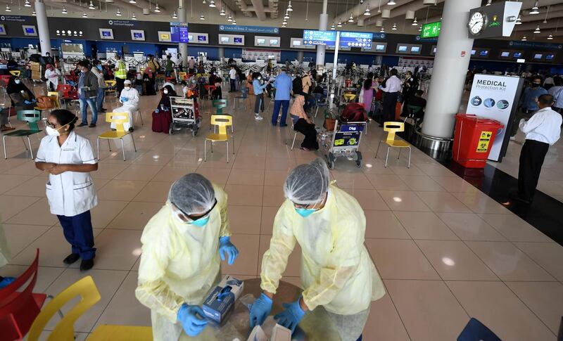 Health workers are pictured at the Dubai International Airport as travellers, including Indian nationals, leave the Gulf Emirate, on May 7, 2020, amid the novel coronavirus pandemic crisis.  The first wave of a massive exercise to bring home hundreds of thousands of Indians stuck abroad was under way today, with two flights preparing to leave from the United Arab Emirates.
India banned all incoming international flights in late March as it imposed one of the world's strictest virus lockdowns, leaving vast numbers of workers and students stranded.

  


  
 / AFP / Karim SAHIB

