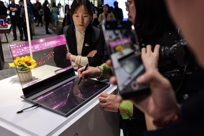 Attendees test a concept ThinkBook laptop computer featuring a transparent display at the Lenovo Group booth on the opening day of the Mobile World Congress in Barcelona. Bloomberg