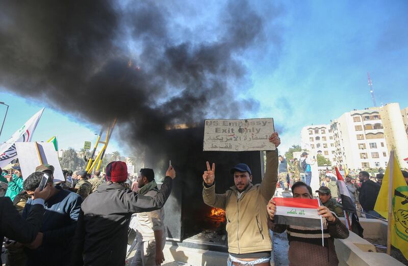 Iraqi protesters set ablaze a sentry box in front of the US embassy building in the capital Baghdad to protest against the weekend's air strikes by US planes on several bases belonging to the Hezbollah brigades near Al-Qaim, an Iraqi district bordering Syria, on December 31, 2019.    Several thousand Iraqi protesters attacked the US embassy in Baghdad on today, breaching its outer wall and chanting "Death to America!" in anger over weekend air strikes that killed pro-Iran fighters. / AFP / Ahmad AL-RUBAYE
