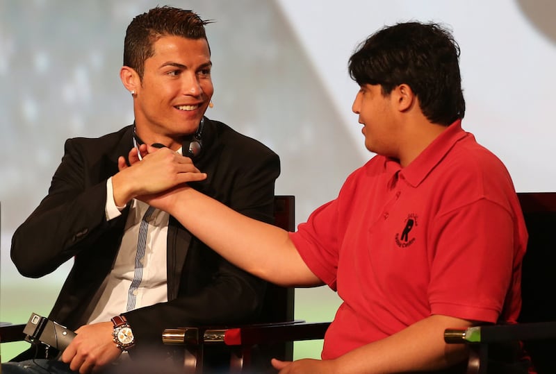 Real Madrid's Cristiano Ronaldo shakes hand with a handicapped young Emirati during the first session of the eighth Dubai International Sports Conference. Marwan Naamani / AFP

