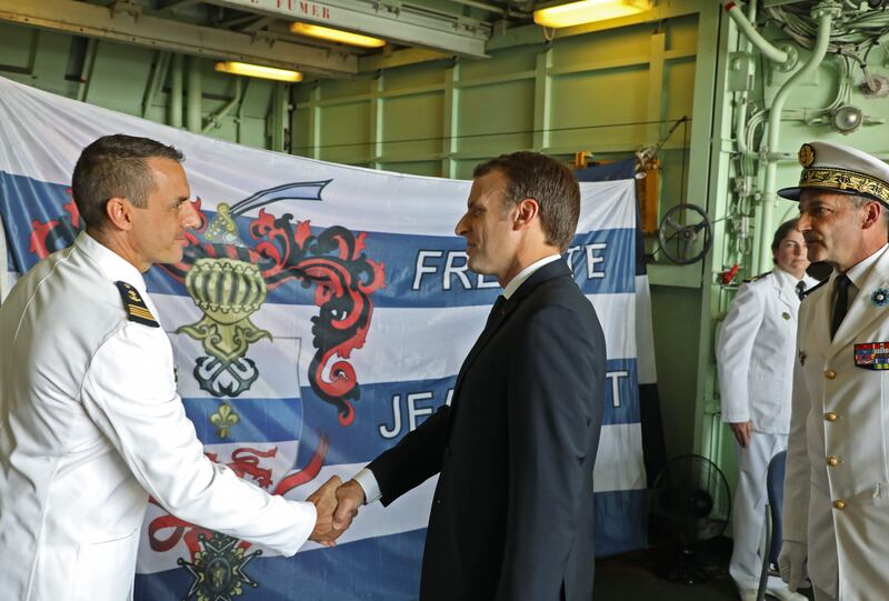 French president Emmanuel Macron is welcomed aboard French warship Jean-Bart at a naval base in Abu Dhabi on November 9, 2017. On the right stands French vice-admiral Didier Piaton. Ludovic Marin / AFP