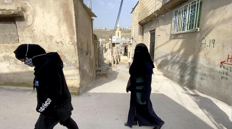 Amani Al Atfal volunteers Miriam and Nouf walk through the streets of Jerash camp. Amy McConaghy / The National