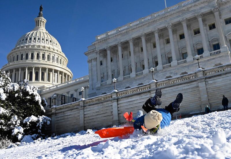 Children use the lawn of the US Capitol to sled on Tuesday in Washington. AFP