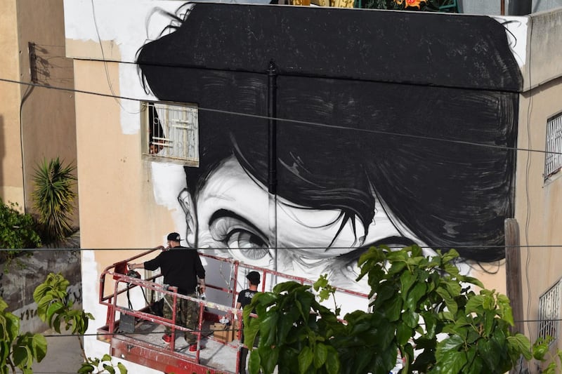 Hombre SUK's mural being worked on. Courtesy Baladk Project