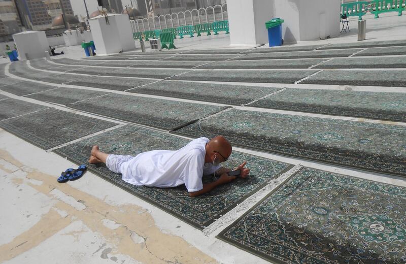 A pilgrim, who entered Saudi Arabia before the country halted travel to the holiest sites, takes a rest on a praying carpet at the roof of the Grand Mosque in the Muslim holy city of Mecca, Saudi Arabia. AP Photo