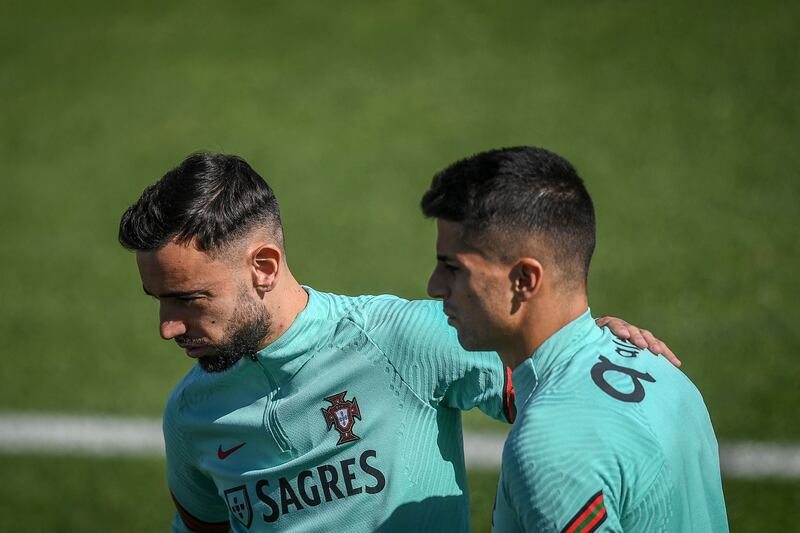 Portugal's midfielder Bruno Fernandes, left, and defender Joao Cancelo during a training session. AFP