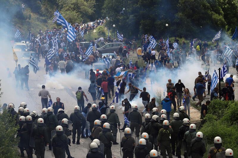 Protestors holding Greek flags clash with riot police during a protest at the village of Pisoderi near the border with Macedonia in northern Greece. AFP
