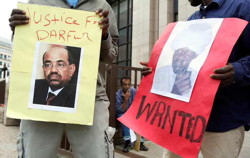 Protesters hold posters of Sudan's former President Omar Al Bashir and Janjaweed leader Ali Kushayb outside the European Union Council in Brussels in 2008.