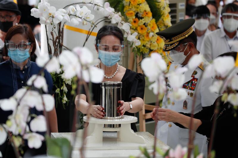 Ballsy Aquino-Cruz holds the urn containing the ashes of her brother, former Philippines president Benigno Aquino III, during burial rites at a cemetery in Paranaque City, Metro Manila. EPA