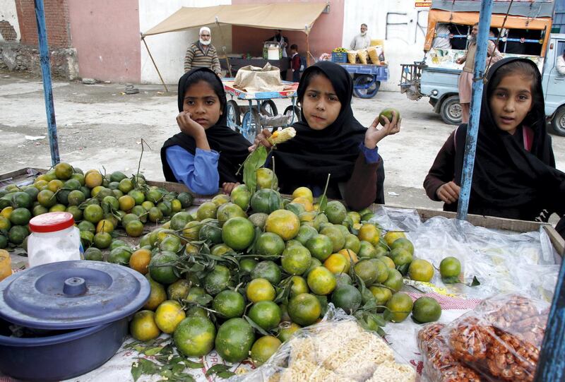 Female students buy fruit from a vendor during recess in once militancy-infested Mingora city of Pakistan‚Äôs Khyber Pakhtunkhwa province. Aamir Saeed for The National