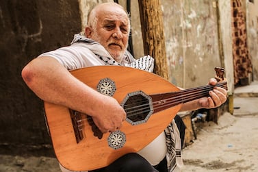 Tawfiq Shanaa, 66, plays the oud outside his house in the Rafah camp for Palestinian refugees in the southern Gaza Strip, June 20. Said Khatib / AFP 