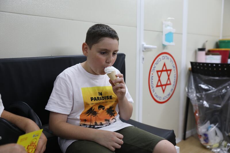 12-year-old Yonatan Rosh eating ice cream he got for free after receiving a Covid-19 vaccine at a vaccination station in Tel Aviv.