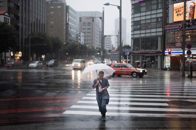 A man protects himself from the rain with an umbrella in Tokyo.  AFP / Martin BUREAU