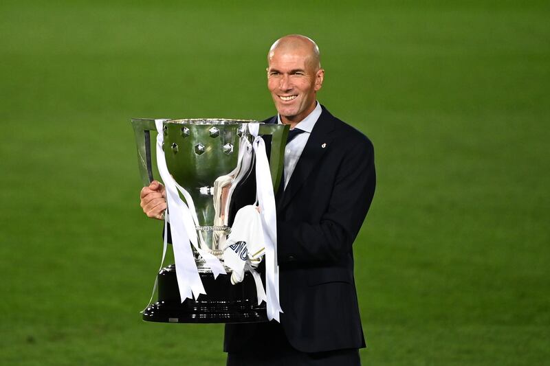 Real Madrid's French coach Zinedine Zidane celebrates winning the Liga title with the trophy after the Spanish League football match between Real Madrid CF and Villarreal CF at the Alfredo di Stefano stadium in Valdebebas, on the outskirts of Madrid, on July 16, 2020. (Photo by GABRIEL BOUYS / AFP)