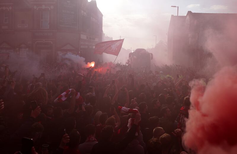 Liverpool fans greet their team bus. PA