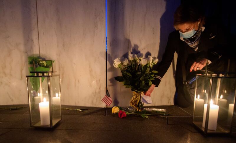 A flight attendant reads a card with flowers at the Wall of Names at the Flight 93 National Monument during the Luminaria Ceremony in Shanksville, Pennsylvania.  AFP