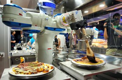 SASEBO, JAPAN - JULY 12:  (CHINA OUT, SOUTH KOREA OUT) Head chef robot 'Andrew' spread sause on the Okonomiyaki, Japanese pancake in the 'Hen na (weird) Restaurant ' during the 'Kingdom of Robot' press preview at the Huis Ten Bosch amusement park on July 12, 2016 in Sasebo, Nagasaki, Japan. The attraction will be opened on July 16.  (Photo by The Asahi Shimbun via Getty Images)