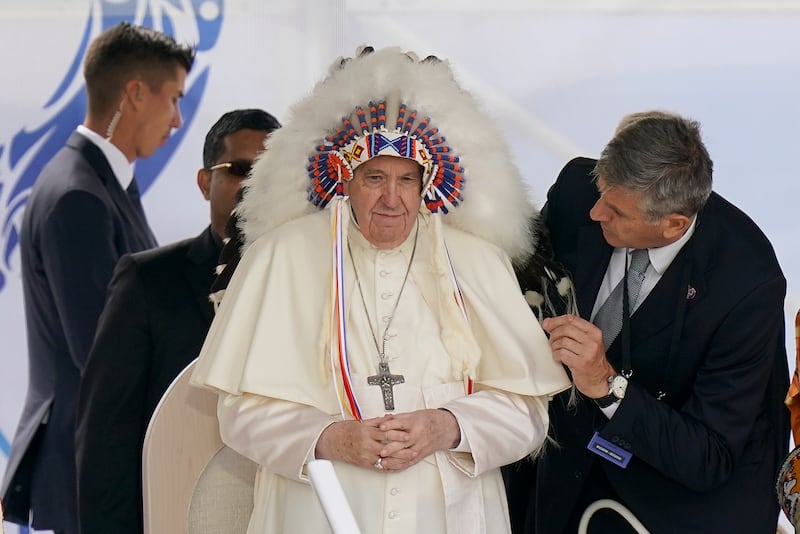Pope Francis dons a headdress given to him during a visit with indigenous people at the site of a former residential school in Maskwacis, Alberta, Canada. AP