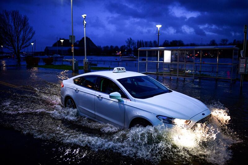 Vehicles make their way through flooding at Dumbarton Quay during storm Dennis in Dumbarton, Scotland. Getty Images