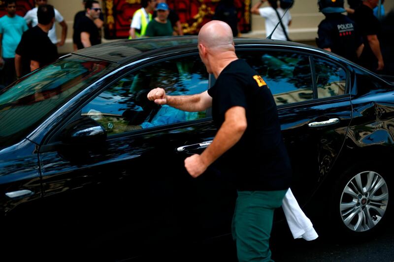 A protesting taxi driver tries to attack the vehicle of an app-based ride-service during a strike by cab drivers in Barcelona.  AFP / Pau Barrena