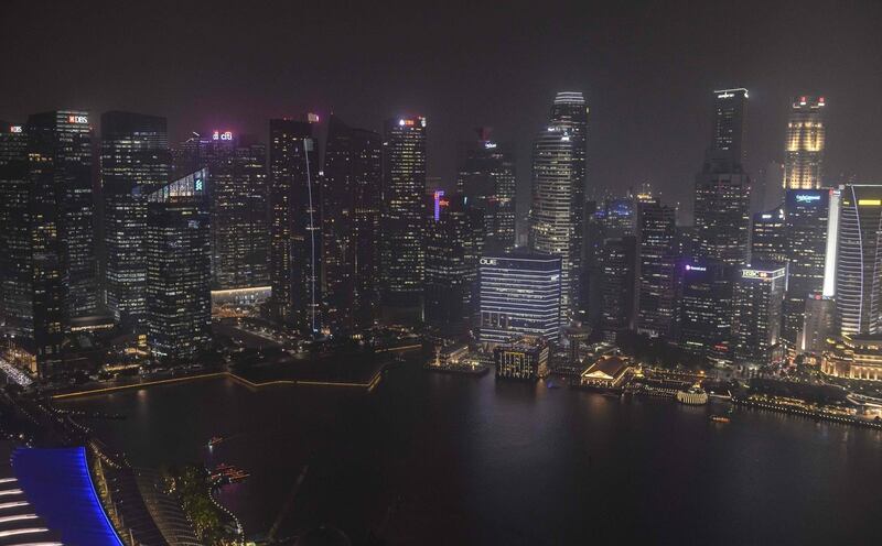 This night time overview shows city skyline of Singapore blanketed by haze on September 18, 2019. Toxic haze from Indonesian forest fires closed thousands of schools across the country and in neighbouring Malaysia on September 18, while air quality worsened in Singapore just days before the city's Formula One motor race. / AFP / Mladen ANTONOV
