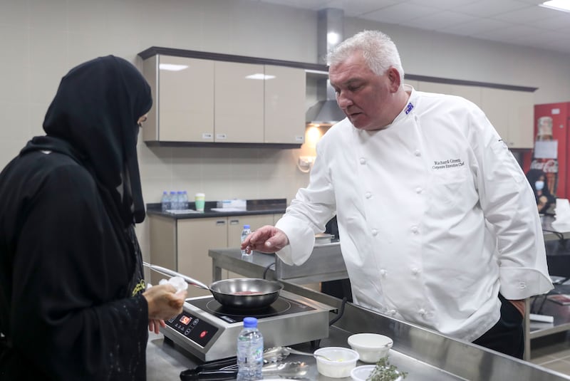 Chef Richard Green observes the women cooking during his class.