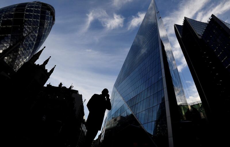A man speaks on his phone as he walks past The Gherkin and other office buildings in the City of London, Britain November 13, 2018. REUTERS/Toby Melville