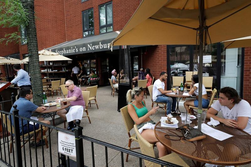 Diners eat in a cafe on Newbury Street, Sunday, June 28, 2020, in Boston. Under step two in phase two of the state's plan to reopen the economy during the coronavirus pandemic, beginning June 22, 2020 restaurants are allowed to serve meals indoors as well as outside. (AP Photo/Steven Senne)