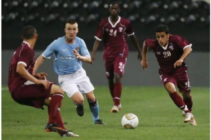Qatar's Saleh Badr, right, and Manchester City's Albert Rusnak in action.