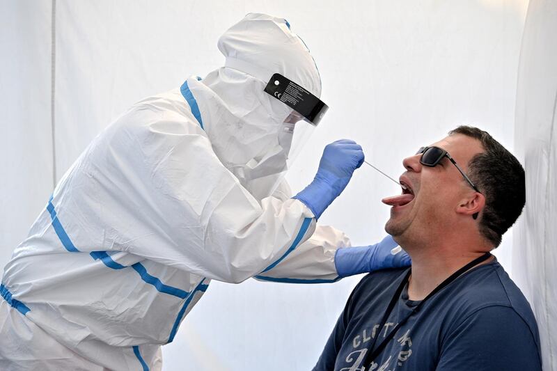 A traveler gets his swab sample collected at a walk-in test centre at the Cologne Bonn Airport in Cologne, Germany. EPA