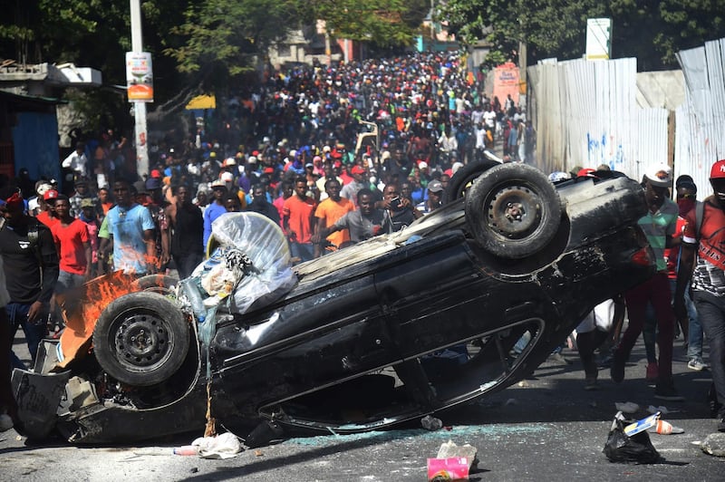 A car is placed as a barricade by demonstratos during clashes in the center of Haitian capital Port-au-Prince. AFP