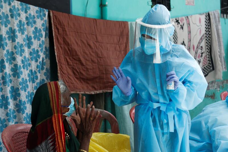 A healthcare worker speaks to a resident about Covid-19 at a check up camp in Dharavi, one of Asia's largest slums, Mumbai, India. Reuters