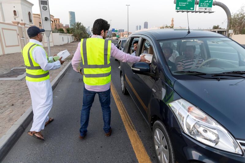 DUBAI, UNITED ARAB EMIRATES. 07 MAY 2019. Iftar meals being distributed to motorists by Marwan Al Hassan (wearing the baseball cap) and his team at the intersection of Al Asayel and 13D Str in Al Quoz 1. (Photo: Antonie Robertson/The National) Journalist: None. Section: National.