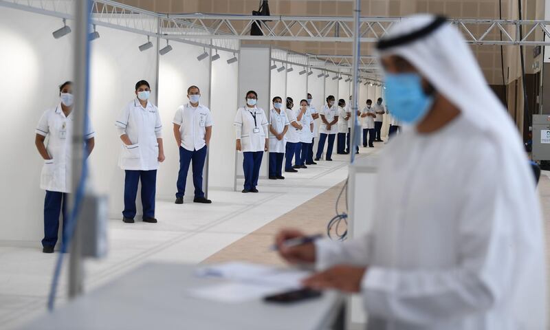 An employee at the Emirati ministry of health sets up to receive patients at a huge field hospital being built by the government of Dubai in the United Arab Emirates, on April 14, 2020, with a capacity of more than 3000 patients at the Dubai international Convention and Exhibition Center amid the COVID-19 pandemic. / AFP / KARIM SAHIB
