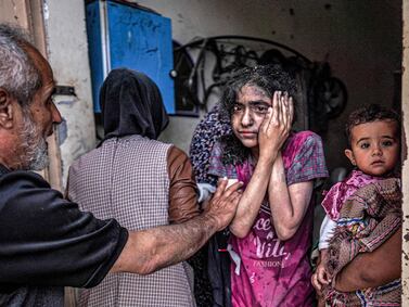 EDITORS NOTE: Graphic content / A man consoles a shocked girl reacting after Israeli bombardment in Nuseirat in the central Gaza Strip on April 29, 2024, amid the ongoing conflict in the Palestinian territory between Israel and the militant group Hamas.  (Photo by AFP)