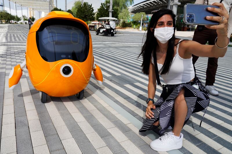A visitor takes a selfie with a wandering robot. AP Photo